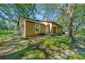 Side view of a tan house with a covered porch at 11250 Ne 220Th St, Fort Mc Coy, FL 32134