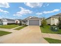 Gray house with two-car garage and landscaped yard; view of neighboring homes at 7193 Sw 64Th Street Rd, Ocala, FL 34474