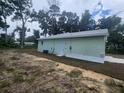 Side view of the house showing its light green exterior and landscaping at 13260 Se 33Rd Ct, Belleview, FL 34420