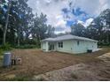 Back of the house showcasing a covered patio and undeveloped lot at 13260 Se 33Rd Ct, Belleview, FL 34420