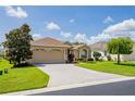 One-story house with a two-car garage and landscaped yard with palm trees at 15890 Sw 11Th Terrace Rd, Ocala, FL 34473