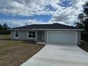 Newly built home with gray siding and a two-car garage at 27 Fisher Trace Trl, Ocklawaha, FL 32179