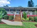 Inviting front porch with wooden stairs and landscaping at 55730 Holiday Cir, Astor, FL 32102