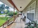 Long wooden front porch with seating and surrounding nature views at 55730 Holiday Cir, Astor, FL 32102