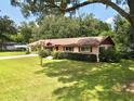 Single story home with side yard and trees at 1779 Ne 12Th St, Ocala, FL 34470