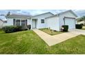 Single-story home with white siding, landscaping and a two-car garage at 892 Nash Loop, The Villages, FL 32162