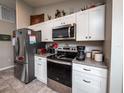 Modern kitchen with stainless steel appliances and white cabinets at 1436 Ne 161St Pl, Citra, FL 32113