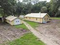 Aerial view of yellow house, detached garage, and surrounding land at 1750 Ne 180Th St, Citra, FL 32113