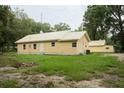 Yellow house with metal roof and detached garage at 1750 Ne 180Th St, Citra, FL 32113