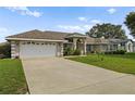 Home with a large driveway and landscaped yard at 5851 Sw 86Th Pl, Ocala, FL 34476