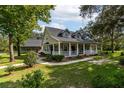 Two-story home with wraparound porch and landscaped yard at 7545 Ne 58Th Ave, Anthony, FL 32617