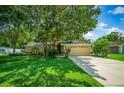Single-story house with a two-car garage and well-manicured lawn at 5311 Se 15Th Ct, Ocala, FL 34480