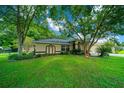 House exterior showcasing a large tree and lush landscaping at 5311 Se 15Th Ct, Ocala, FL 34480