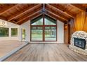 Living room with vaulted ceiling, fireplace, and large windows at 10100 Sw 186Th Ave, Dunnellon, FL 34432