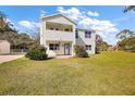Two-story house with light yellow siding, gray roof and a spacious yard at 10 Se Chinica Drive, Summerfield, FL 34491
