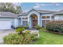 Light blue house with a double door entry, landscaping, and a two-car garage at 12880 Sw 66Th St, Ocala, FL 34481