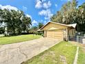 Ranch style home with a two-car garage and spacious driveway at 26 Juniper Pass Ln, Ocala, FL 34480