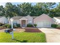 Pink single-story house with a two-car garage and well-maintained lawn at 11696 Sw 71St Cir, Ocala, FL 34476