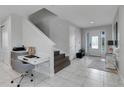 Bright entryway with tile floors, staircase, and built-in workspace at 7694 Graben St, Kissimmee, FL 34747