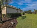 Side view of house showing lush landscaping and golf course views at 9240 Se 128Th Ln, Summerfield, FL 34491