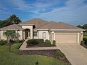One-story home with a two-car garage, manicured lawn and landscaping at 9240 Se 128Th Ln, Summerfield, FL 34491