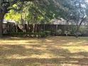 Spacious backyard with mature trees and wooden fence at 2712 Ne 26Th St, Ocala, FL 34470