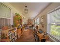 Bright sunroom features hardwood floors and built-in workspace at 12369 Se 130Th Ct, Ocklawaha, FL 32179