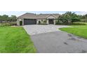 Single-story home with a large driveway and landscaped lawn at 1620 Nw 73Rd Ter, Ocala, FL 34482