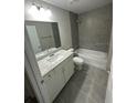 Bathroom with a shower/tub combo, vanity, and gray tile at 14239 Sw 19Th Pl, Ocala, FL 34481