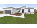 Modern home with gray garage door and white exterior at 4820 Sw 159Th Lane Rd, Ocala, FL 34473