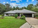 Single-story home with a metal roof, black garage door and landscaped yard at 14670 W Highway 328, Ocala, FL 34482