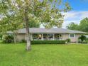 Ranch-style home with a large front porch and well-manicured lawn at 8580 Sw 203Rd Ct, Dunnellon, FL 34431