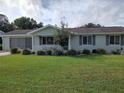 House with green siding and a well-maintained lawn at 8750 Sw 116Th Place Rd, Ocala, FL 34481