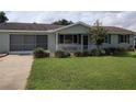 Ranch-style home with carport, landscaping and lawn at 8750 Sw 116Th Place Rd, Ocala, FL 34481