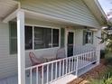 Covered porch with red chairs and a small table at 8750 Sw 116Th Place Rd, Ocala, FL 34481