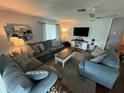 Living room with gray sofas, wood floors, and a white brick accent wall at 16 Spring Drive Way, Ocala, FL 34472