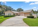 Tan house with three-car garage and landscaped yard at 11196 Ne 227Th Place Rd, Fort Mc Coy, FL 32134
