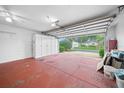 Garage with storage cabinets and red flooring at 17521 Se 96Th Ct, Summerfield, FL 34491