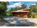 Three-car garage with paver driveway and wood siding at 21820 Sw 87Th Loop, Dunnellon, FL 34431