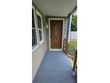 Inviting front porch with wood door and gray flooring at 1510 Nw 48Th St, Ocala, FL 34475