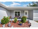 Front porch with decorative landscaping and bench at 4611 Se 136Th Ln, Summerfield, FL 34491