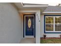 Modern house entrance with a navy blue door and white trim at 32 Juniper Pass Trak, Ocala, FL 34480