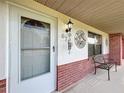 Front entrance with a white door, sidelights, and a bench at 6789 Se 54Th Ln, Ocala, FL 34472