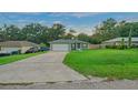 House exterior featuring a green house with a white garage door and landscaped yard at 4810 Nw 60Th Ter, Ocala, FL 34482