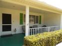 Front porch with green shutters, white railing, and rocking chairs at 9223 Sw 109Th Ln, Ocala, FL 34481