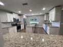 Modern kitchen with white cabinets, granite counters, and stainless steel appliances at 9526 Sw 72Nd Ct, Ocala, FL 34476