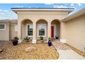 House exterior with arched entryway and red door at 6470 Sw 50Th Ct, Ocala, FL 34474