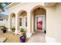 House exterior with arched entryway and red door at 6470 Sw 50Th Ct, Ocala, FL 34474