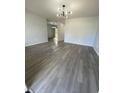 Spacious living room with gray vinyl flooring and chandelier at 5 Hickory Track Run, Ocala, FL 34472