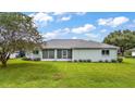 House with screened porch, surrounded by a large grassy backyard at 2051 Nw 50Th Ave, Ocala, FL 34482
